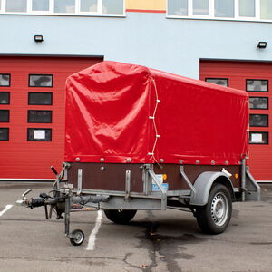 Materialanhänger der Feuerwehr steht vor Rolltoren eines Feuerwehrstützpunktes