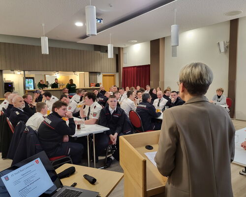 Versammlung im Saal des Grünen Baumes, Bürgermeisterin steht am Pult und redet (Rückenaufnahme)