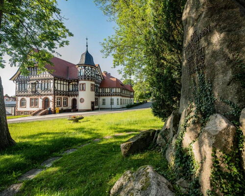 Landschaftsaufnahme mit Historischer Post und Kriegerdenkmal im Vordergrund