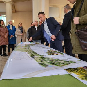 ein Mann zeigt auf eine Stelle in einem großen gezeichneten Plan