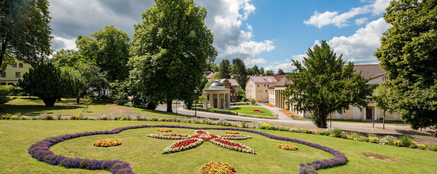 Sternenbeet mit Blumenornamenten, im Hintergrund Bad Liebensteiner Brunnentempel und Comödienhaus