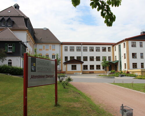 dreistöckiges Schulgebäude im Stil eines Dreiseitenhofes