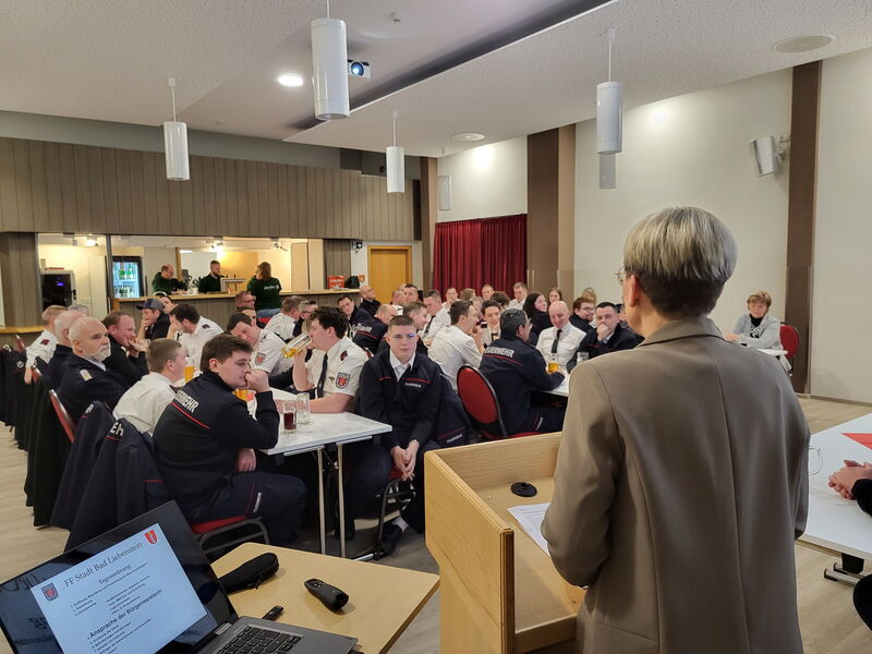 Versammlung im Saal des Grünen Baumes, Bürgermeisterin steht am Pult und redet (Rückenaufnahme)