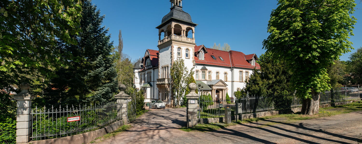 Haus mit Schlosscharakter und gemauerter Hofeinfahrt, darin befindet sich ein Seniorenpark