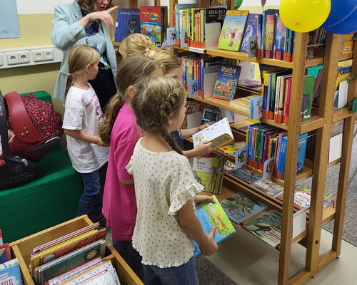 Kinder stehen vor einem Buchregal