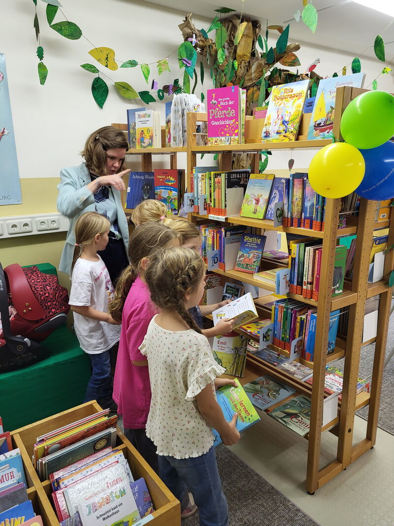 Kinder stehen vor einem Buchregal